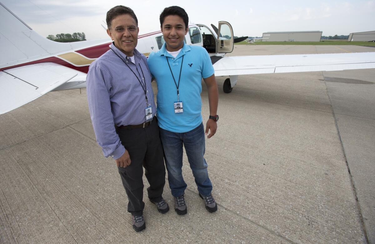 Babar Suleman, 58, and his son Haris Suleman, 17, stand next to their plane in Greenwood, Ind., on June 19 before taking off for their around-the-world flight.