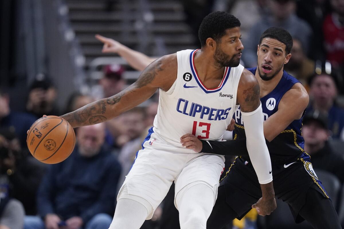 Clippers forward Paul George protects his dribble from the reach of Pacers guard Tyrese Haliburton.