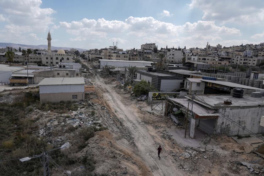 A man walks on a damaged road following an Israeli army raid in Jenin, West Bank, on Wednesday, Sept. 4, 2024. (AP Photo/Majdi Mohammed)