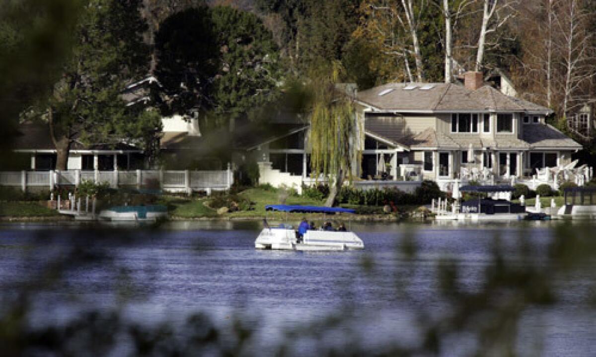 An electric boat cruises on the lake in Westlake Village.