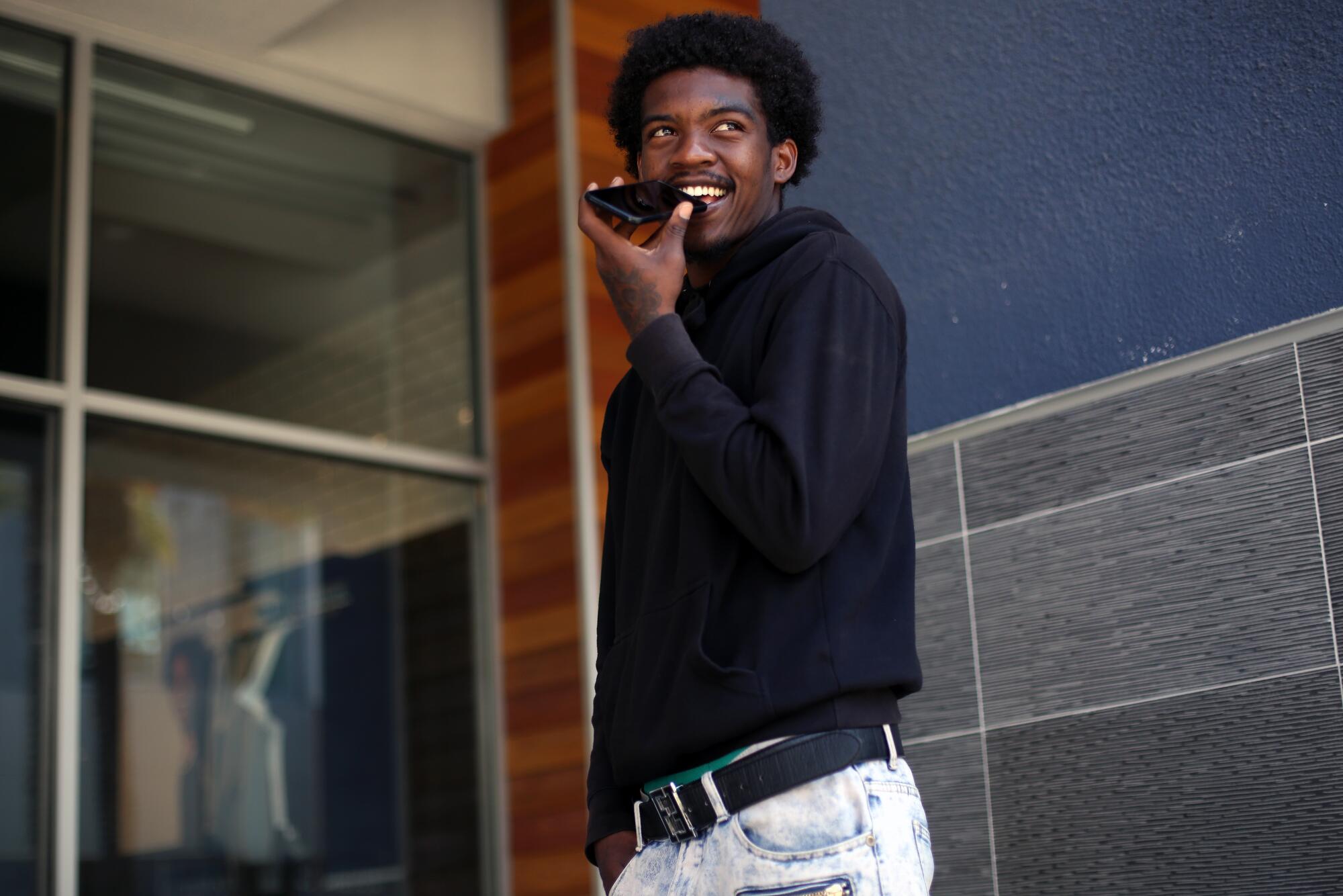 Ja'quest Jones, 19, holds a phone to his face to talk to Dave Stein, a mentor and volunteer with CASA