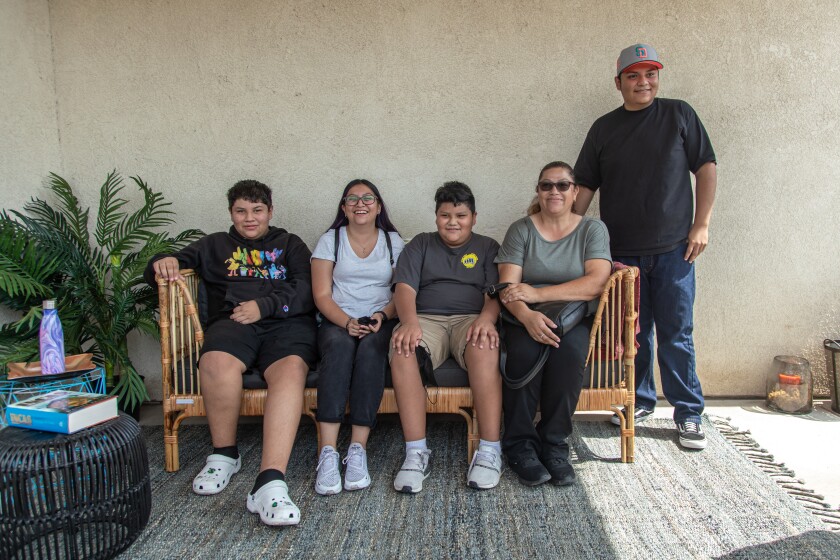 Nicolas, Natalia, Adrian, Clara and Francisco take in the changes in their new backyard on their outdoor couch.