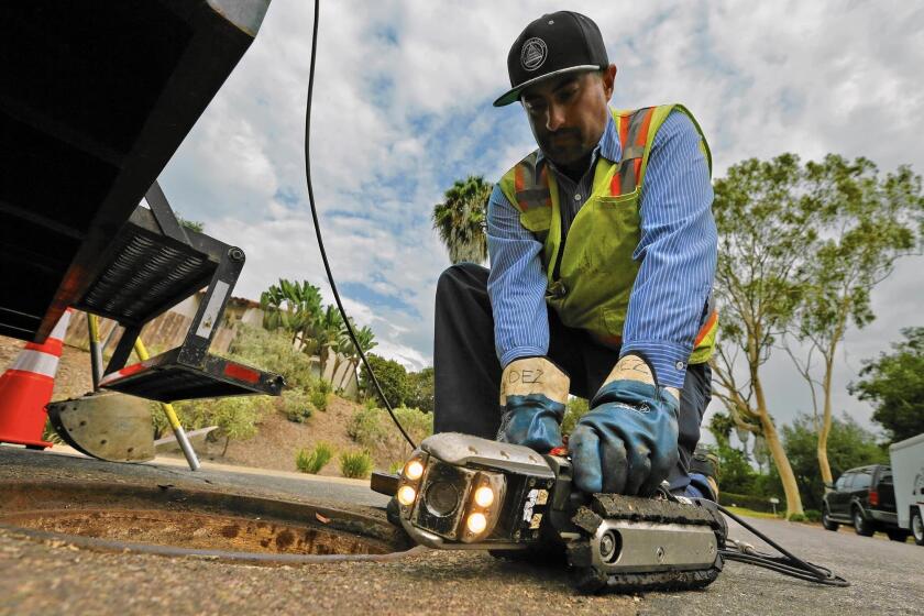 Hugo Gonzalez, a Leucadia Wastewater District technician, prepares a camera to search for roots in a Carlsbad, Calif., sewer line. Without normal levels of outdoor irrigation, tree roots in search of water have invaded sewer pipes and grown there over time.