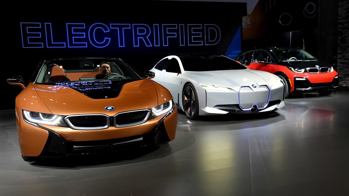 Among the electric cars at the 2017 LA Auto Show are a BMW 2019 i8 Roadster plug-in hybrid, left, the BMW i Vision Dynamics electric concept car and a Mini Cooper plug-in hybrid.