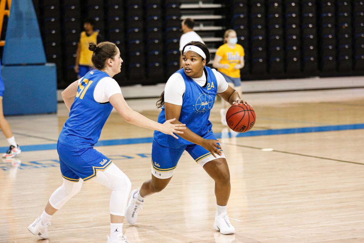 IImar'I Thomas, right, dribbles the ball under pressure during UCLA basketball practice.