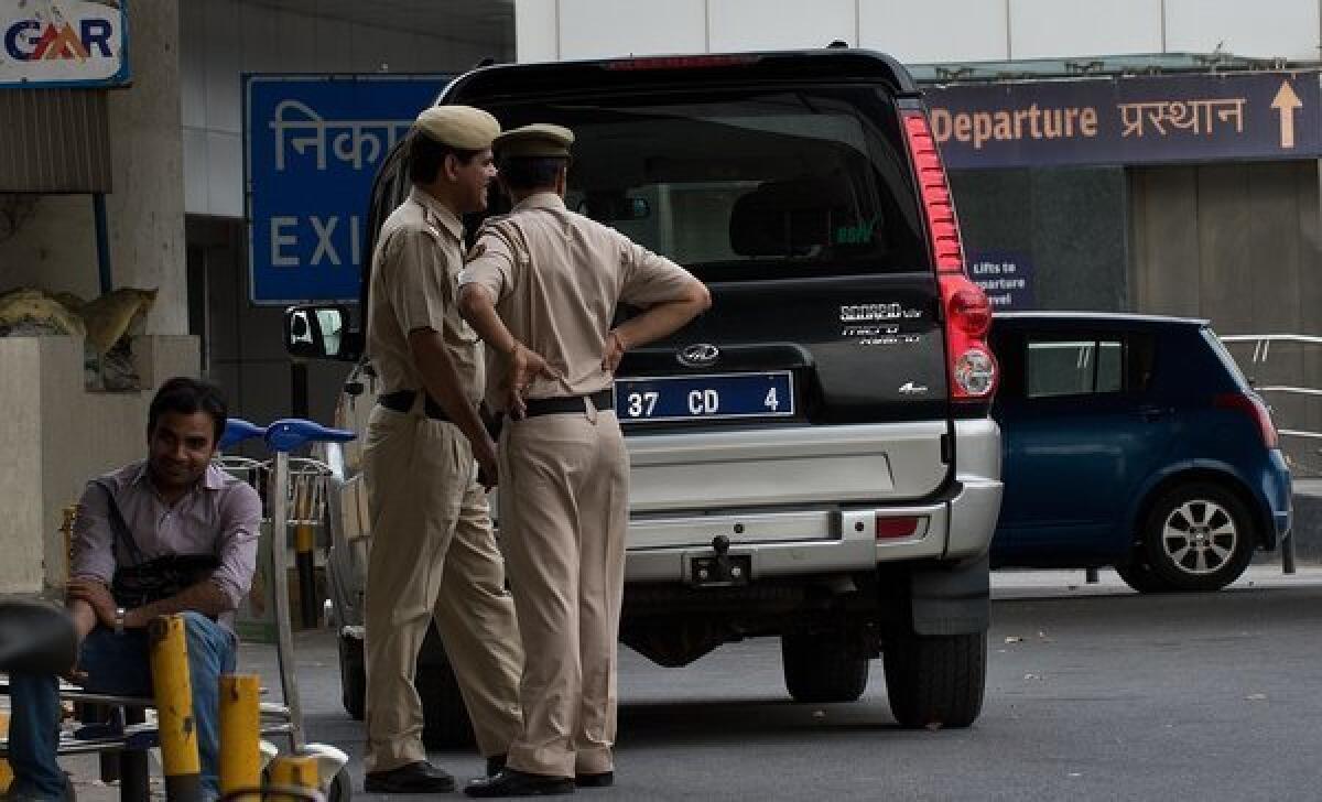 Indian police stand guard near a Italian Embassy vehicle Friday prior to the arrival of Italian marines at Indira Gandhi International airport in New Delhi.
