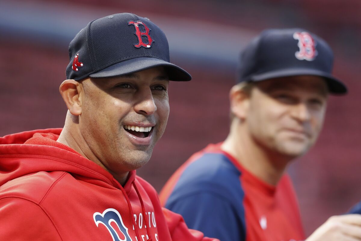 Boston Red Sox manager Alex Cora watches the team's baseball workout with bench coach Tim Hyers, right, Saturday, Oct. 9, 2021, in Boston. The Red Sox hosts the Tampa Bay Rays in Game 3 of the American League Division Series on Sunday. (AP Photo/Michael Dwyer)