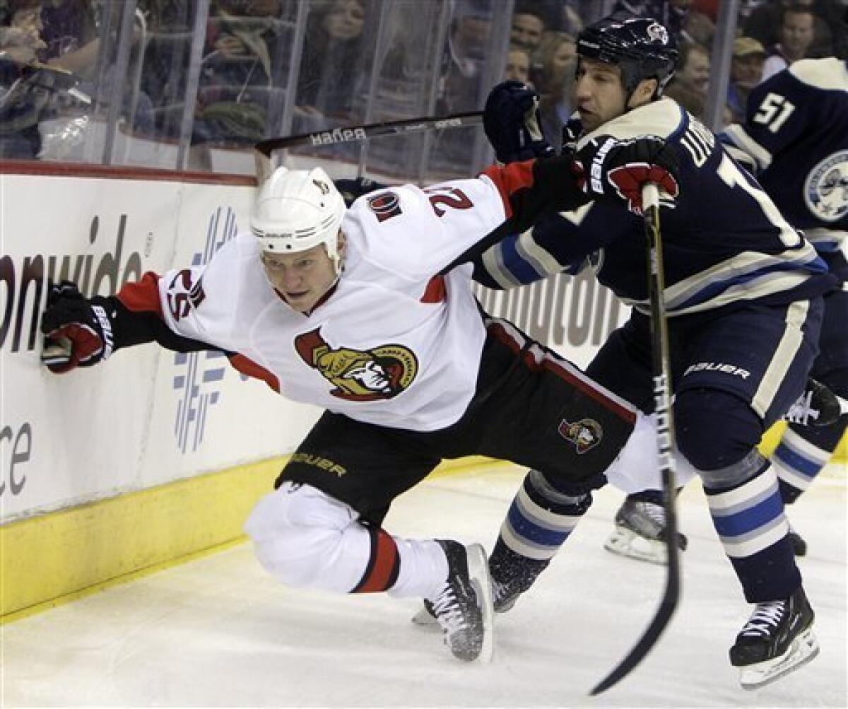 Ottawa Senators' Chris Neil, right, fights for control of the puck