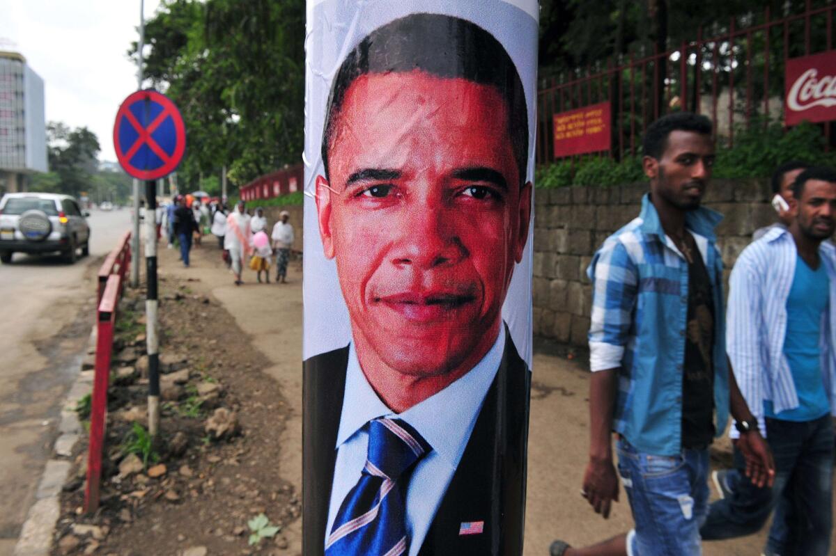Pedestrians walk past a poster of President Obama before his arrival in Addis Ababa, Ethiopia, on July 26, 2015.