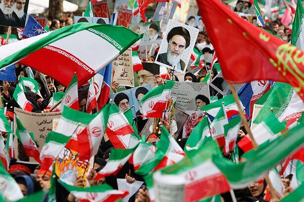 Flag-waving Iranian schoolgirls attend an annual demonstration in front of the former U.S. Embassy in Tehran on Wednesday in a ceremony commemorating the 30th anniversary of the seizure of the U.S. Embassy by militant students on Nov. 4, 1979. The poster at top center shows late revolutionary founder Ayatollah Khomeini.