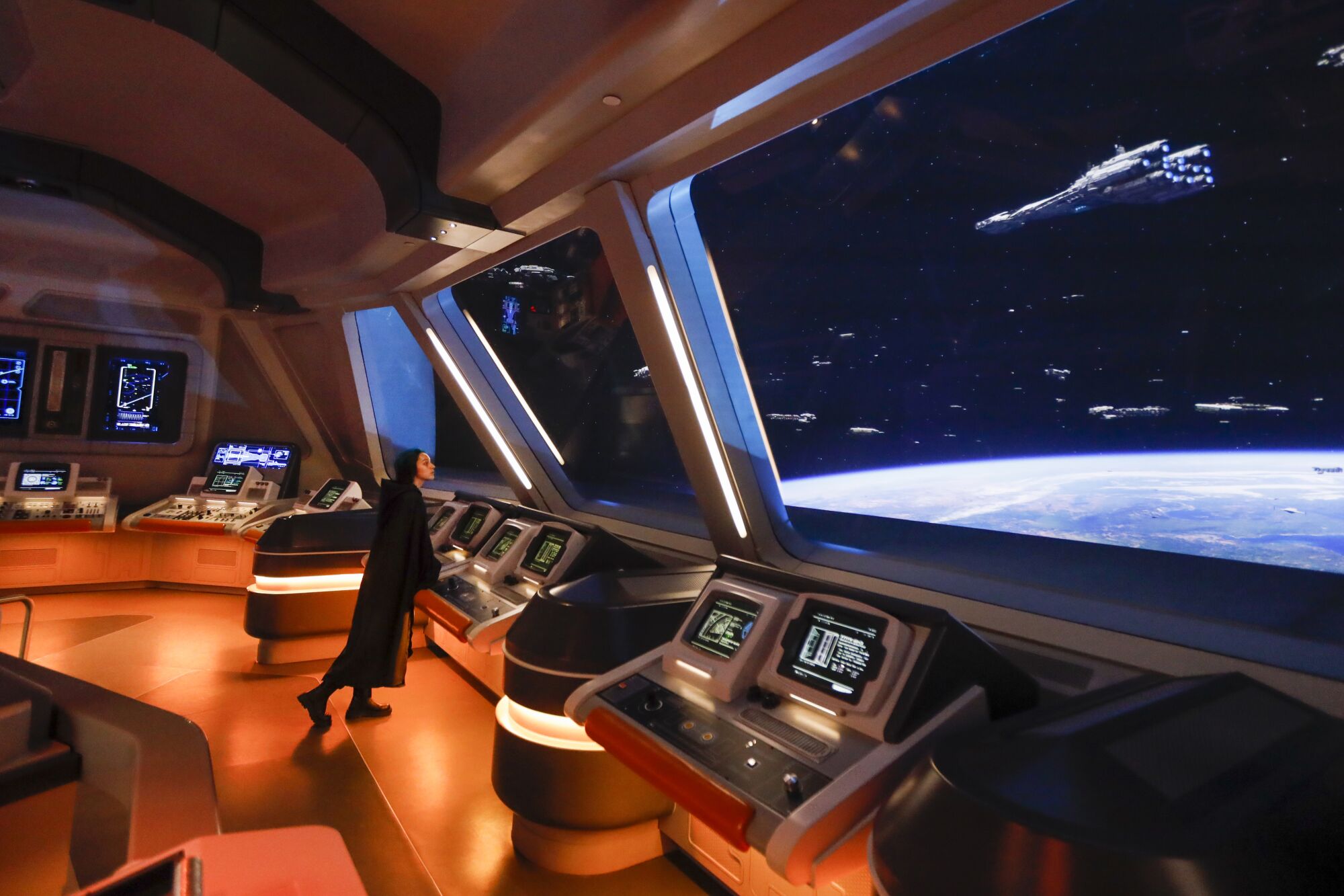 A passenger views the starship control room and bridge as ships pass by.
