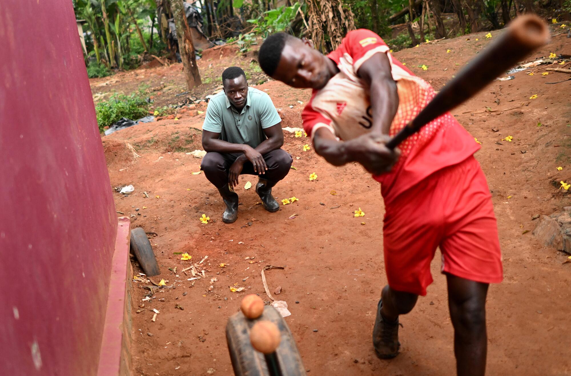 Coach Paul Wafula instructs Dennis Kasumba on his swing in Gayaza, Uganda.