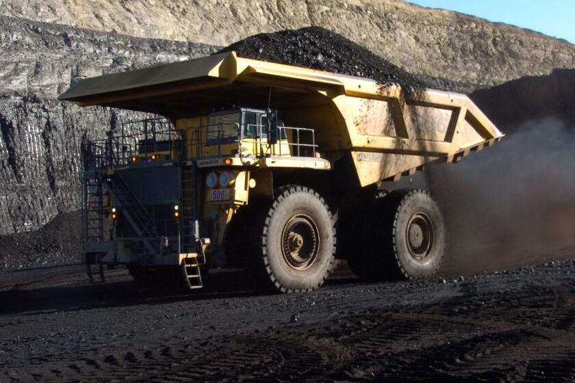 FILE - In this Nov. 15, 2016, file photo, a haul truck with a 250-ton capacity carries coal from the Spring Creek strip mine near Decker, Mont. As President Donald Trump touts new oil pipelines and pledges to revive the nationâs struggling coal mines, federal scientists are warning that burning fossil fuels is already driving a steep increase in the United States of heat waves, droughts and floods. (AP Photo/Matthew Brown, File)