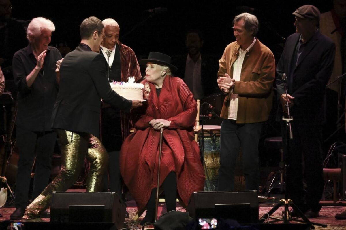 Joni Mitchell blew out birthday cake candles as the crowd serenaded her at Wednesday's "Joni 75" celebration.
