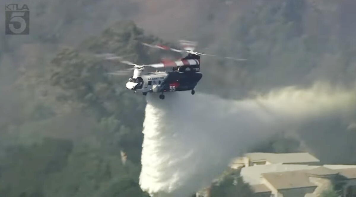 On Monday, a helitanker poured water on the Paros Island fire burning in the La Habra Highlands.