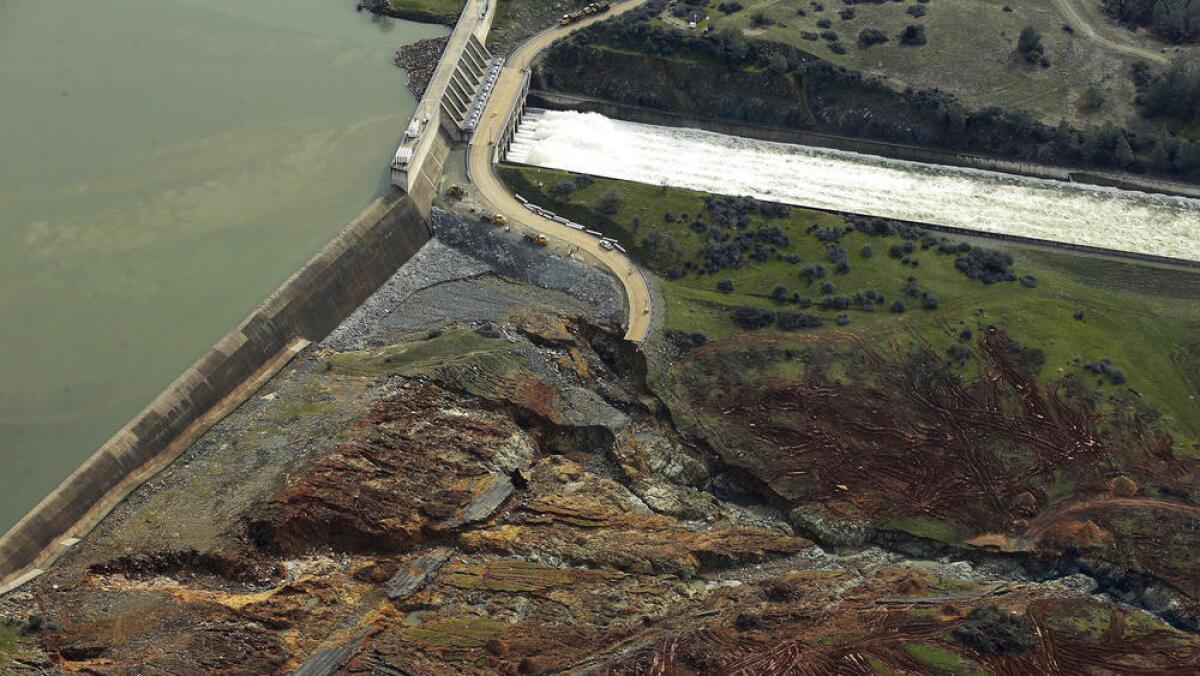 An aerial view shows the emergency spillway in the left part of this photo—a low concrete wall over which excess water spills over. Officials were alarmed that earth near the base of the concrete wall at Lake Oroville was rapidly eroding, which could cause the wall to collapse.
