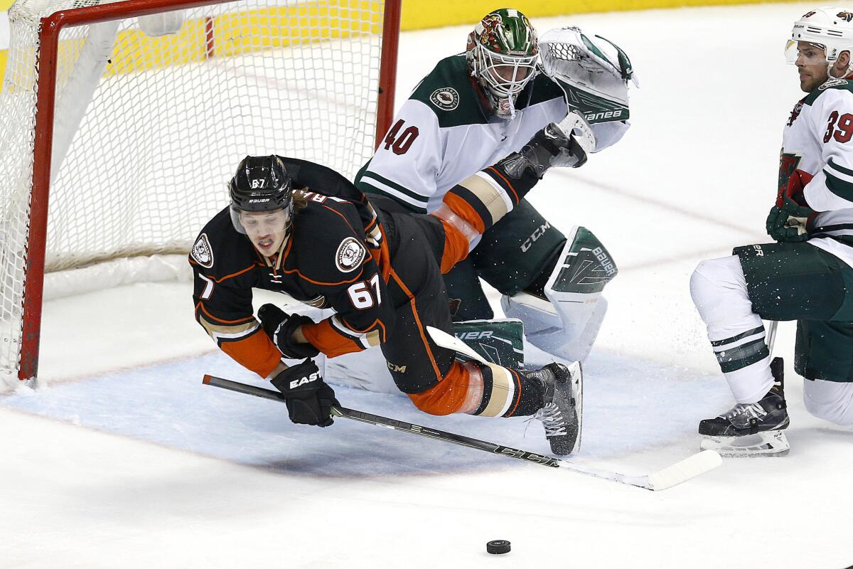 Ducks center Rickard Rakell goes all out in pursuit of a puck as Minnesota Wild goalie Devan Dubnyk hovers nearby on Jan. 20.