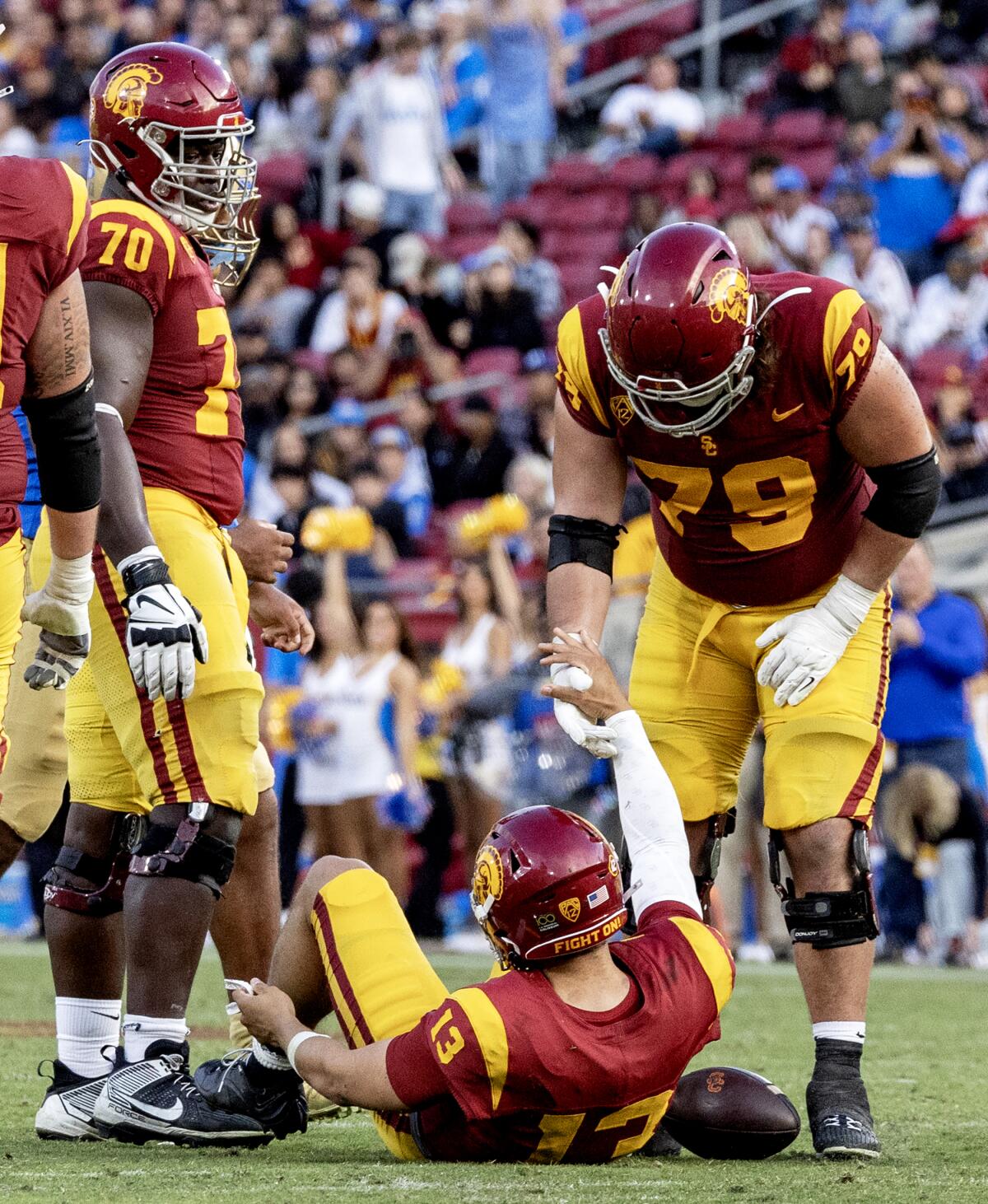 USC offensive lineman Jonah Monheim helps quarterback Caleb Williams to his feet after he was sacked 