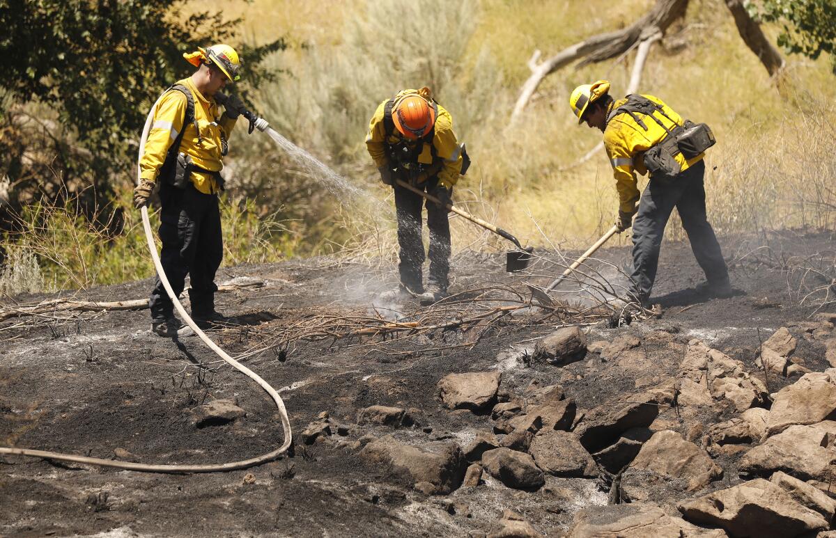 Los Angeles County firefighters work to extinguish flare-ups from the Soledad fire July 6.