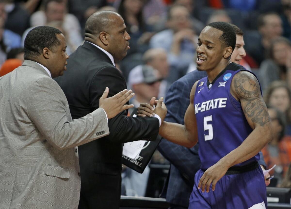 Barry Brown is congratulated by Kansas State's coaching staff as he leaves the floor during an NCAA tournament game against Creighton.
