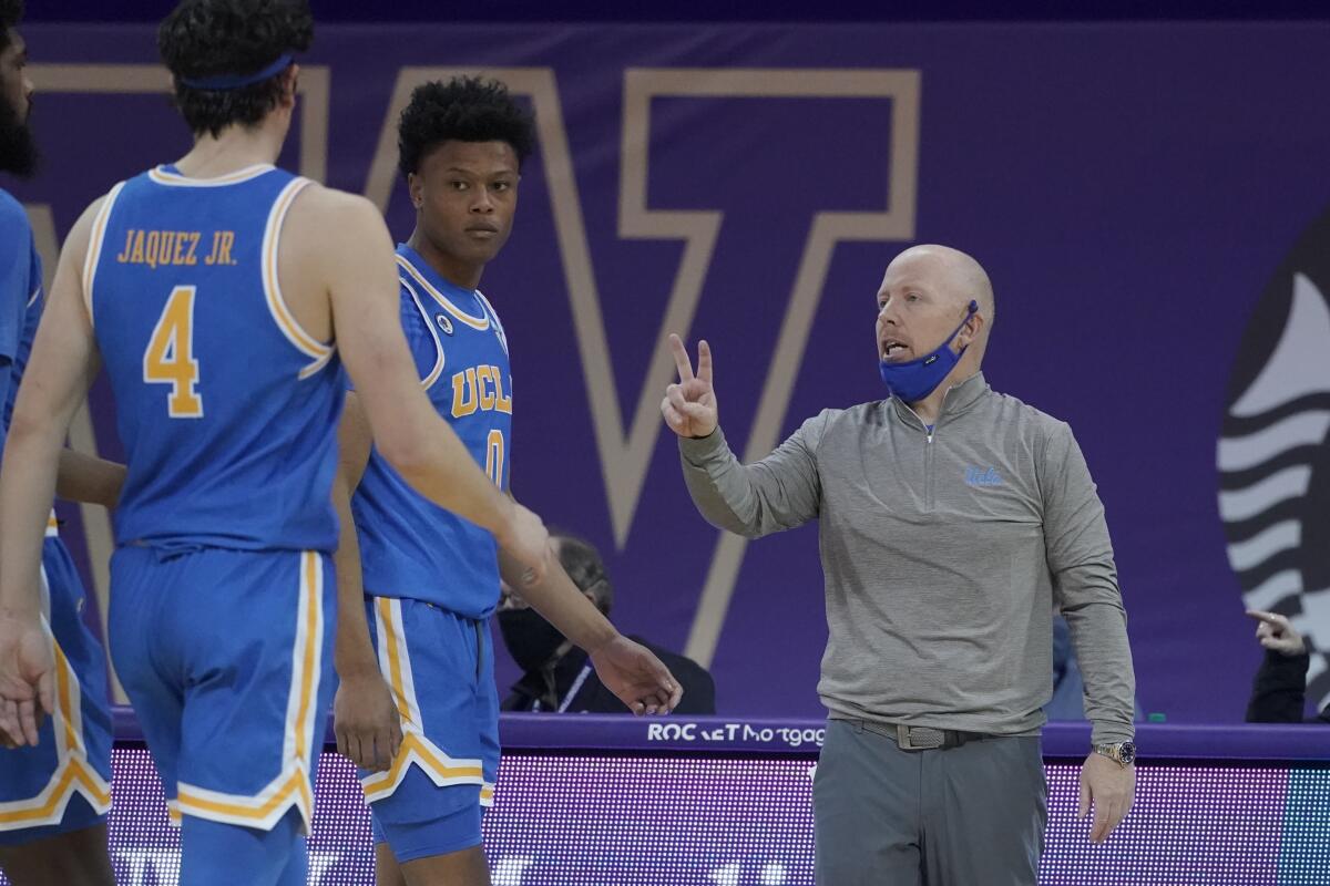 UCLA head coach Mick Cronin, right, talks to guard Jaime Jaquez Jr.