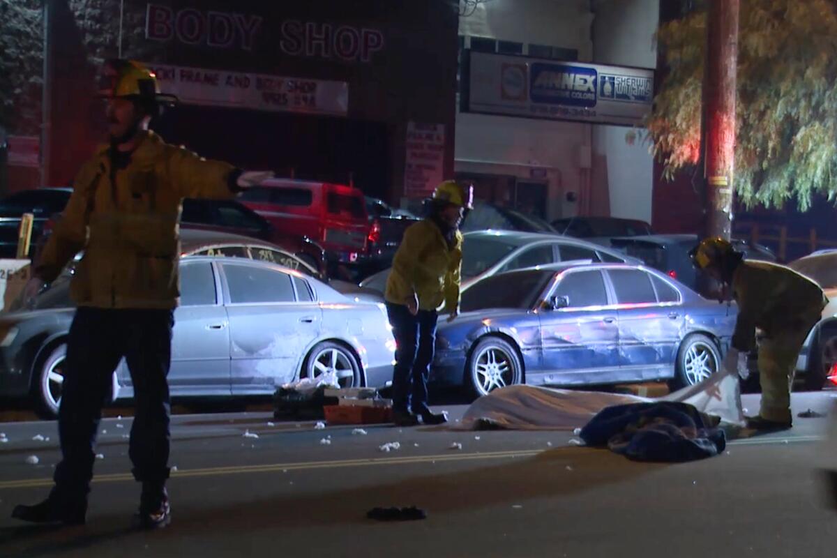 Firefighters and police respond at the scene where a pedestrian was killed in Pacoima by drivers who did not stop