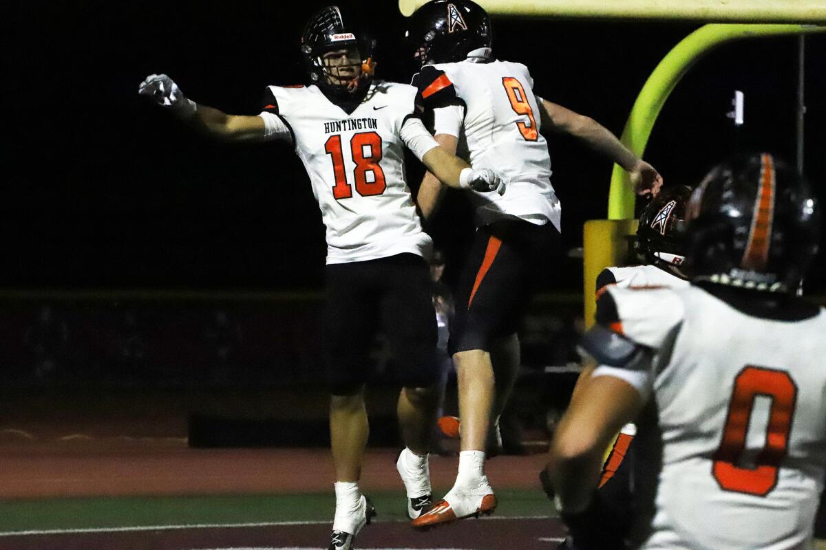 Huntington Beach's Troy Foster (18) and Brady Edmunds (9) celebrate a touchdown against Simi Valley on Friday.