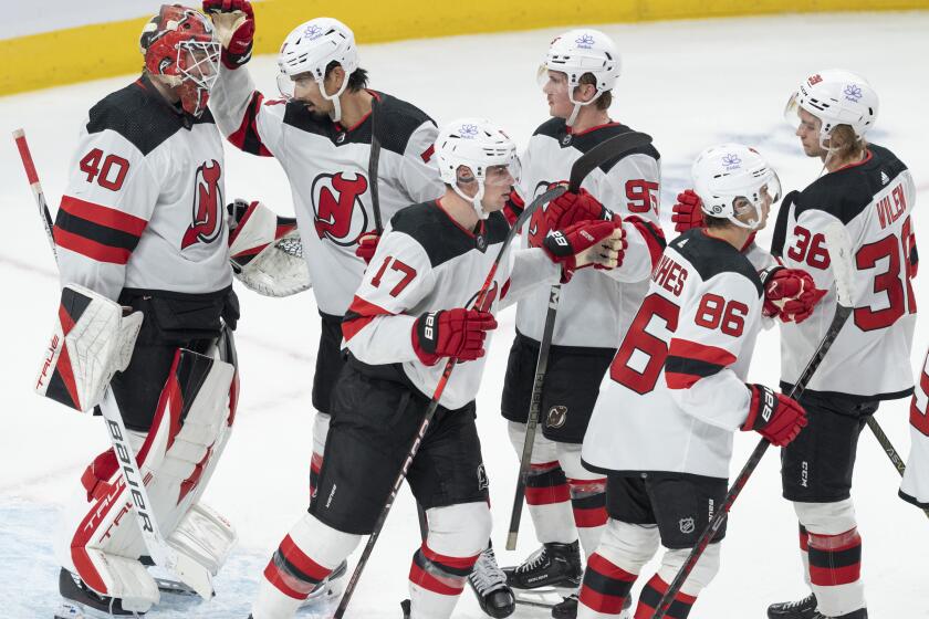 New Jersey Devils goaltender Akira Schmid (40) is congratulated by teammates after their win over the Montreal Canadiens in preseason NHL hockey game action in Montreal, Monday, Sept. 25, 2023. (Christinne Muschi/The Canadian Press via AP)