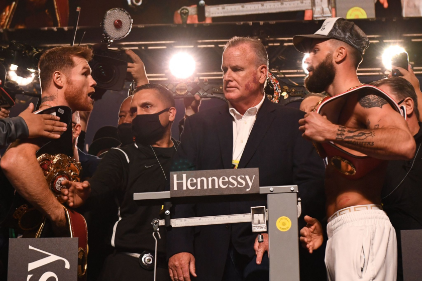 Boxers Canelo Alvarez (L) and Caleb Plant (R) stand on stage during their weigh-in.