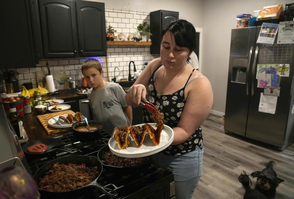 Tiffany O'Neil adds carne asada to her tacos before joining her family at the dining room of their home in Randall, Iowa.