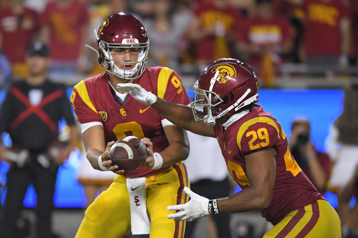 USC quarterback Kedon Slovis, left, hands off to running back Vavae Malepeai during the Trojans' win over Fresno State on Saturday.