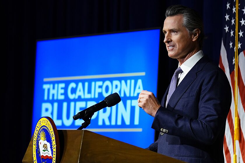 California Gov. Gavin Newsom unveils the revised budget plan during a news conference in Sacramento.