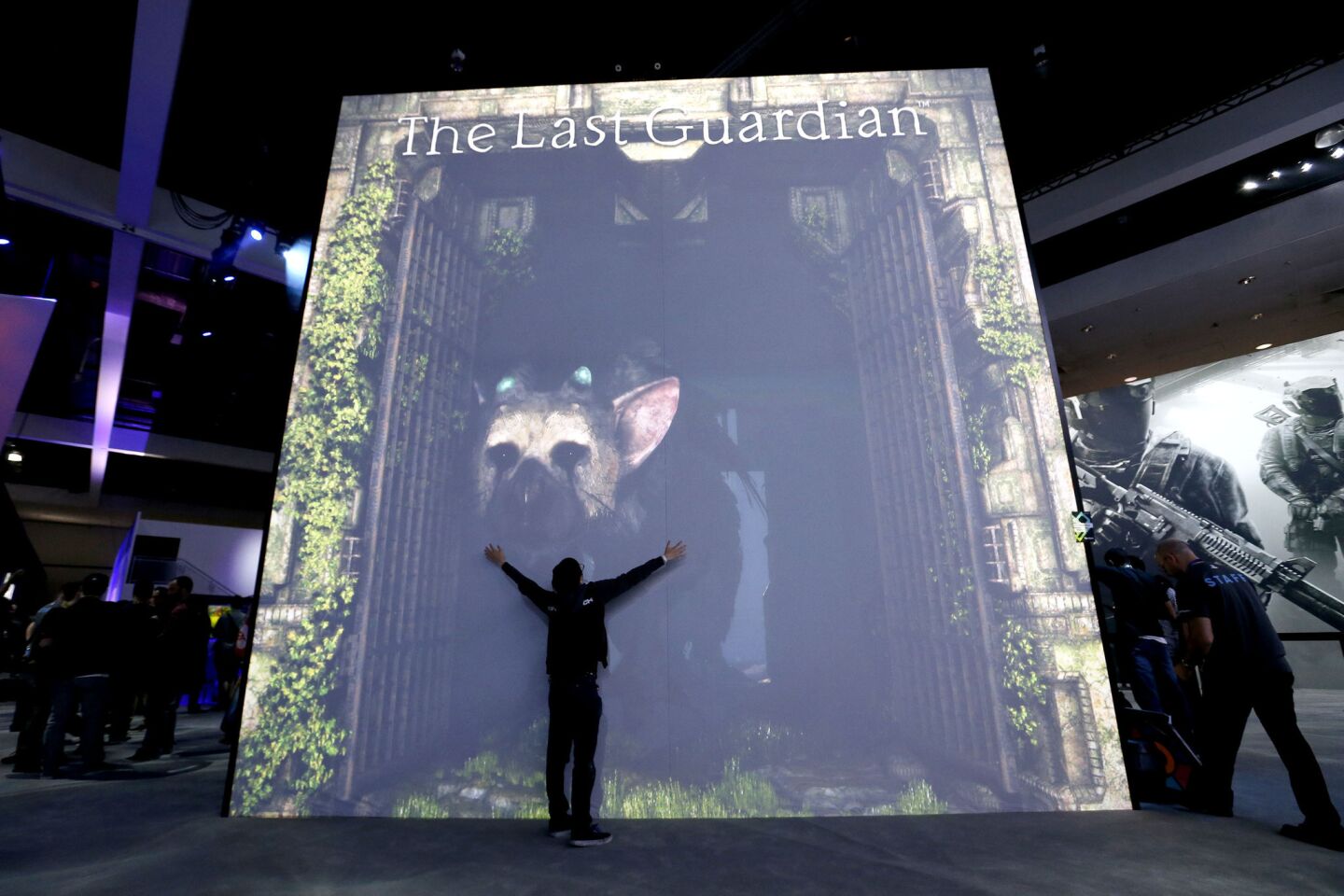 Jesse Diep gives "Trico," a beast from "The Last Guardian" Sony PlayStation 4 exclusive game to be released Oct. 25, an interactive hug at E3. People are able to feed and pet the beast through a large projection and sensor system.