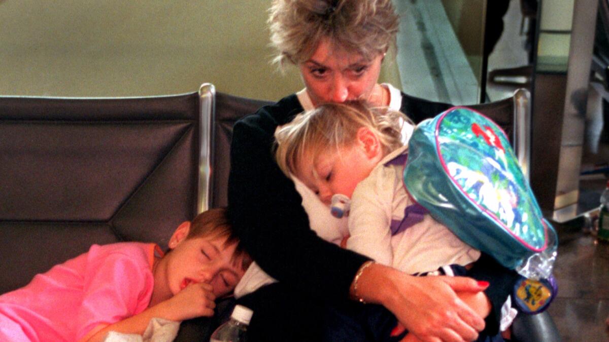 Shelly Goettelmann waits at John Wayne Airport to board a plane to Pittsburgh while her children catch a nap. An India-based airline has added a child-free zone for people who want a quiet flight.