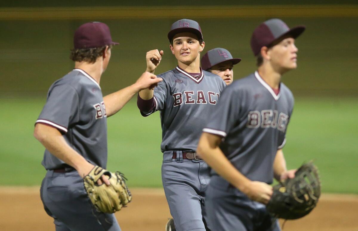 Laguna Beach High pitcher Cutter Clawson, left, congratulates second baseman Charlie Pillsbury after throwing out a runner at first base in the Ryan Lemmon Baseball Tournament championship game against Yorba Linda at Irvine's Orange County Great Park on Wednesday.