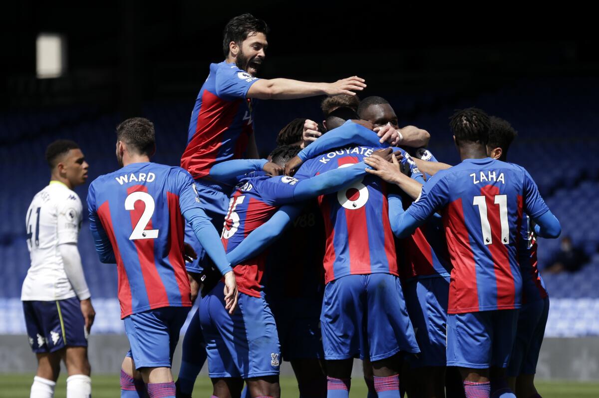 Crystal Palace's Tyrick Mitchell,obscured, is congratulated by teammates after scoring his team's third goal during the English Premier League soccer match between Crystal Palace and Aston Villa at Selhurst Park in London, Sunday, May 16, 2021. (AP Photo/Henry Browne/Pool)