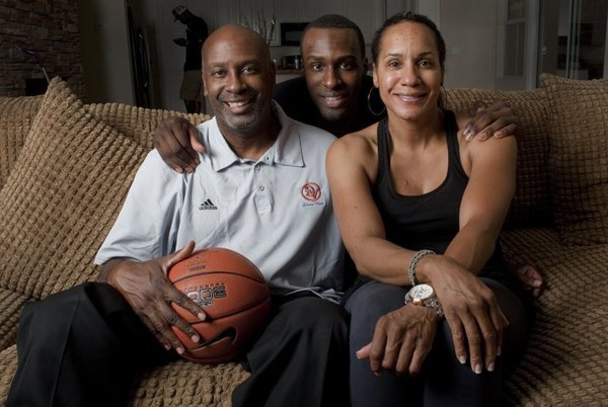 Ron Holmes, left, with son Shabazz Muhammad and wife Faye Muhammad at their Las Vegas home in 2011. Holmes began shaping his son's basketball career before he was born in Long Beach in 1992.