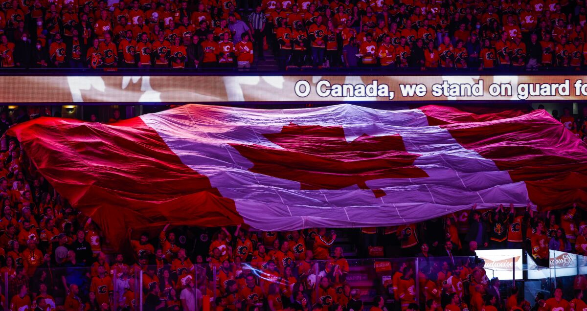 Calgary Flames fans sing the Canadian national anthem before Game 1 of the team's NHL hockey first-round playoff series against the Dallas Stars on Tuesday, May 3, 2022, in Calgary, Alberta. (Jeff McIntosh/The Canadian Press via AP)