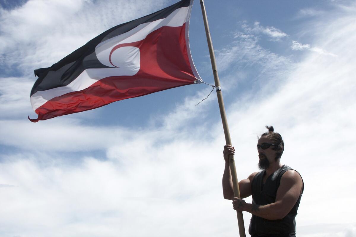A man flies the red, black and white Maori flag 