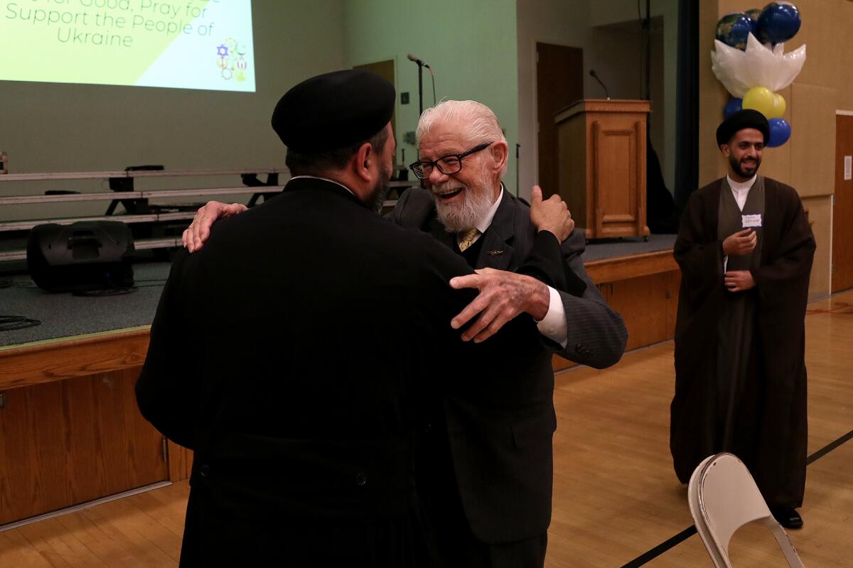 Tom Thorkelson, center, a NMIIC board member, shares a laugh with Fr. Paul Baky Mikhail, left.