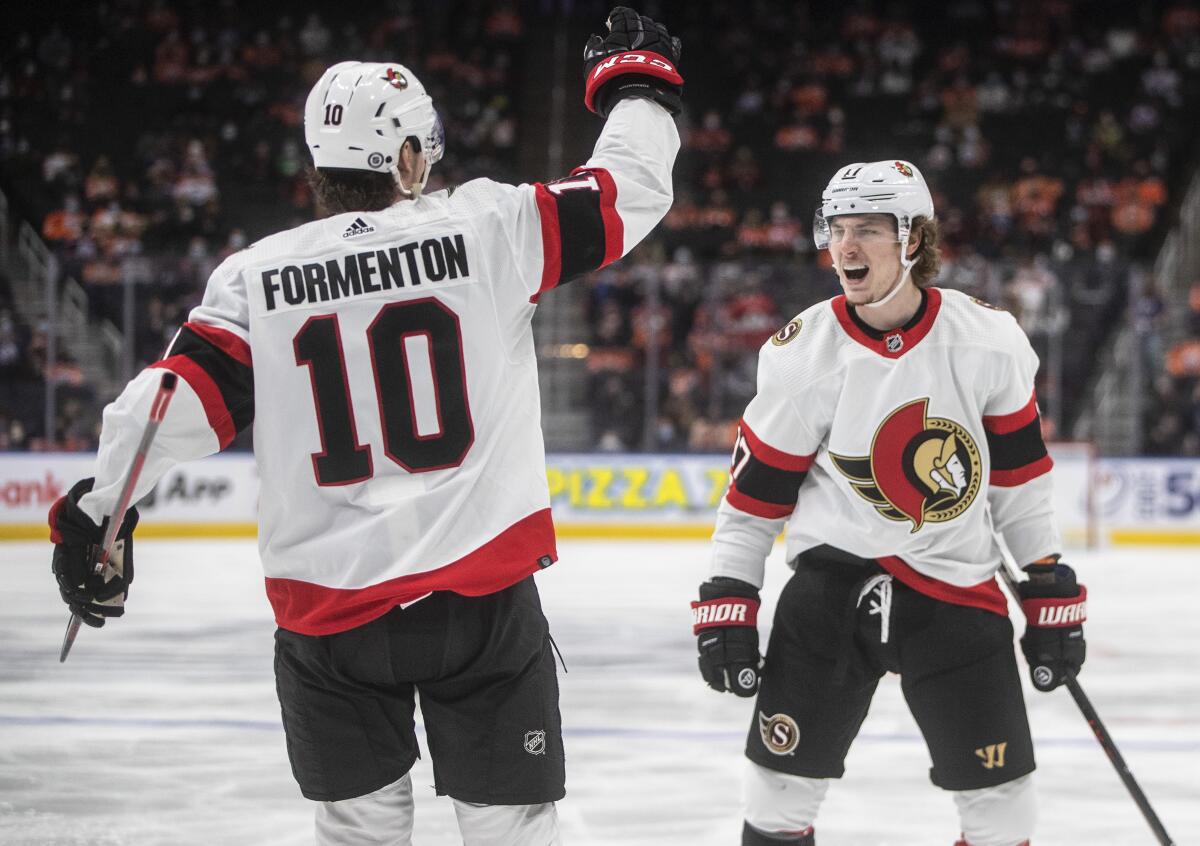 Ottawa Senators' Alex Formenton (10) and Adam Gaudette (17) celebrate a goal against the Edmonton Oilers during the third period of an NHL hockey game, Saturday, Jan. 15, 2022 in Edmonton, Alberta. (Jason Franson/The Canadian Press via AP)