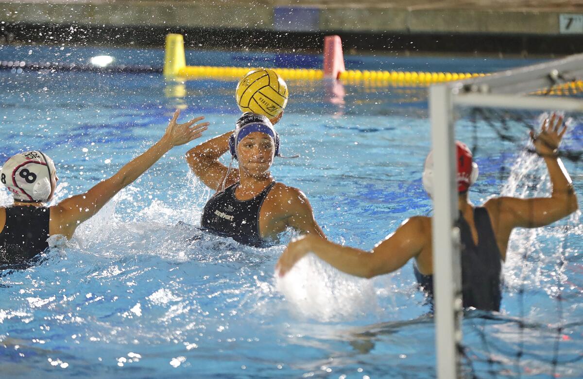 Newport Harbor's Caitlin Stayt, center, takes a shot on Corona del Mar goalie Sarah Decker during Battle of the Bay match.