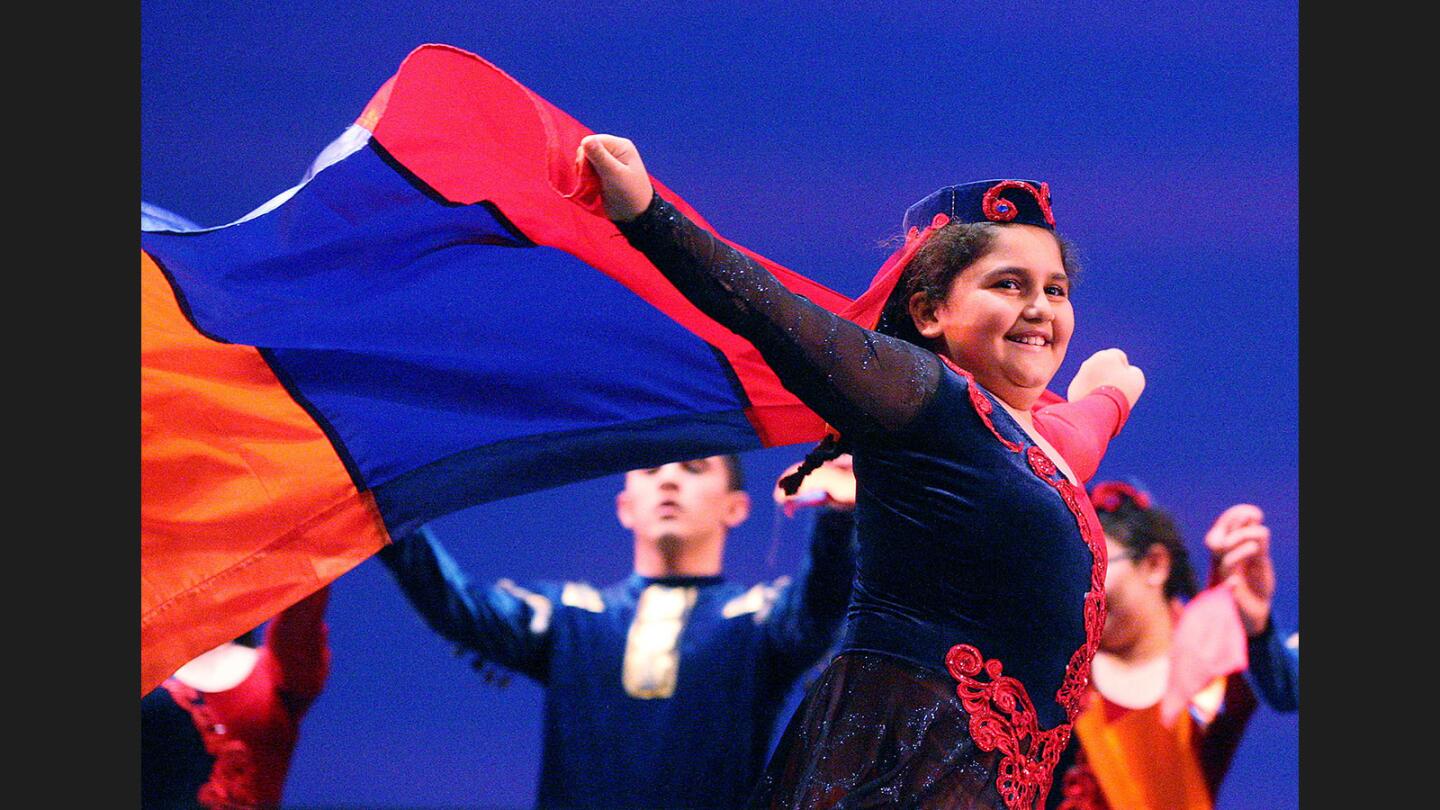 A girl with the Lilia Dance Studio runs with an Armenian flag across the stage at the 16th Annual Armenian Genocide Commemoration at Glendale High School on Wednesday, April 19, 2017.