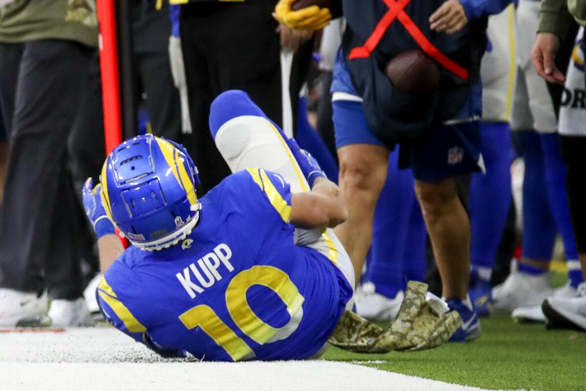 Rams wide receiver Cooper Kupp rolls out of bounds holding his right leg after suffering an injury in November.
