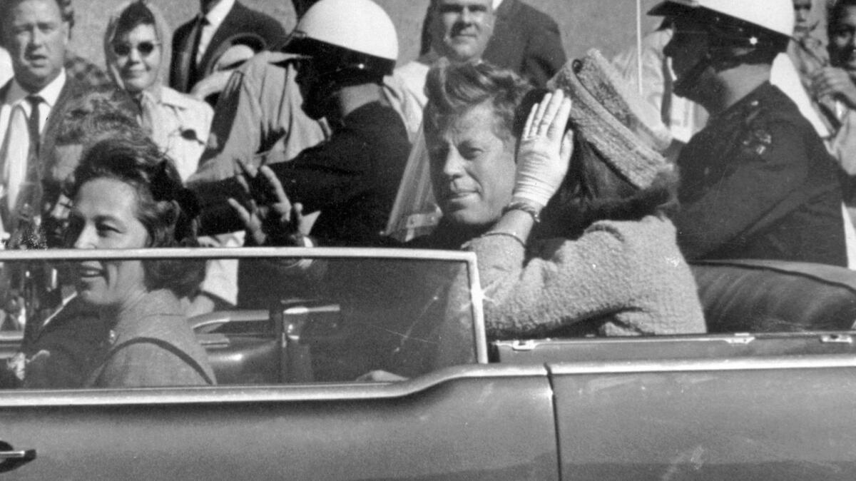President John F. Kennedy waves from his car in a motorcade before his assassination in Dallas. The National Archives released the John F. Kennedy assassination files on Oct. 26, 2017.