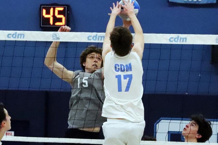 Newport Harbor's Jack Berry (15) and CdM's Ryan Grant (17) joust for the ball during Newport Harbor High School boys' volleyball team against rival Corona del Mar High School boys' volleyball team in the Battle of the Bay Surf League match at Corona del Mar High School in Newport Beach on Friday, March 15, 2024. (Photo by James Carbone)