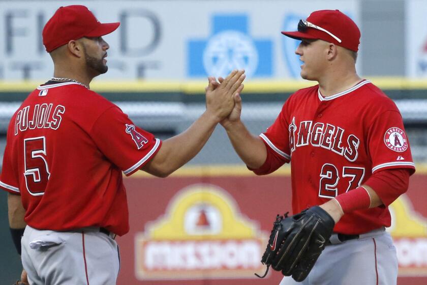 Angels teammates Albert Pujols, left, and Mike Trout celebrate following the team's 8-4 win over the Chicago White Sox in the first game of a doubleheader Tuesday.