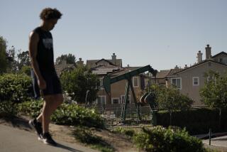 FILE - A man walks along the street as a pump jack extracts oil at a drilling site next to homes Wednesday, June 9, 2021, in Signal Hill, Calif. Stop the Energy Shutdown, a campaign organized by oil and gas industry groups, said Tuesday, Dec. 13, 2022, it has collected enough signatures for a referendum to overturn SB 1137, the law that banned new oil and gas wells within 3,200 feet of highly populated places. (AP Photo/Jae C. Hong, File)
