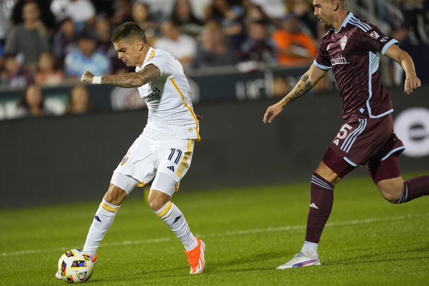 Los Angeles Galaxy forward Gabriel Pec, left, kicks the ball for a goal as Colorado Rapids defender Andreas Maxsø covers in the second half of an MLS soccer match Wednesday, Oct. 2, 2024, in Commerce City, Colo. (AP Photo/David Zalubowski)