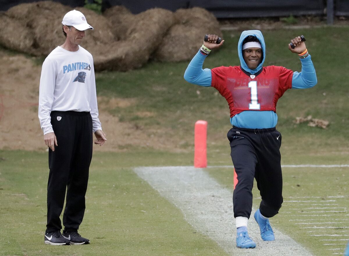 FILE - In this May 22, 2019, file photo, then-Carolina Panthers' Cam Newton (1) stretches on the sidelines as then-head trainer Ryan Vermillion watches during the NFL football team's practice in Charlotte, N.C. The Washington Football Team has placed head athletic trainer Ryan Vermillion on administrative leave for what a spokesman calls an ongoing criminal investigation unrelated to the club. Vermillion is in his second season with coach Ron Rivera in Washington after 18 seasons working for the Carolina Panthers. (AP Photo/Chuck Burton, File)